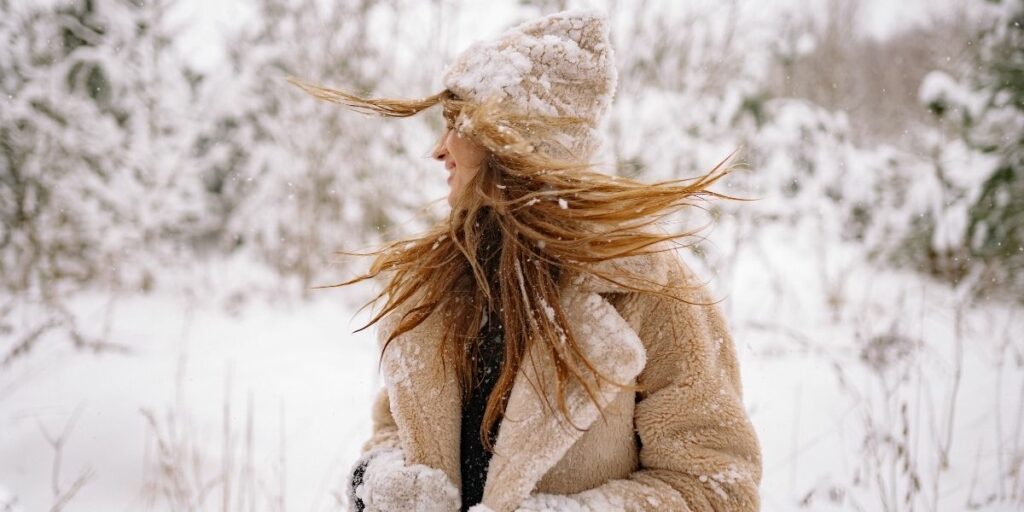 Femme heureuse sous la neige, après sa routine d'hiver