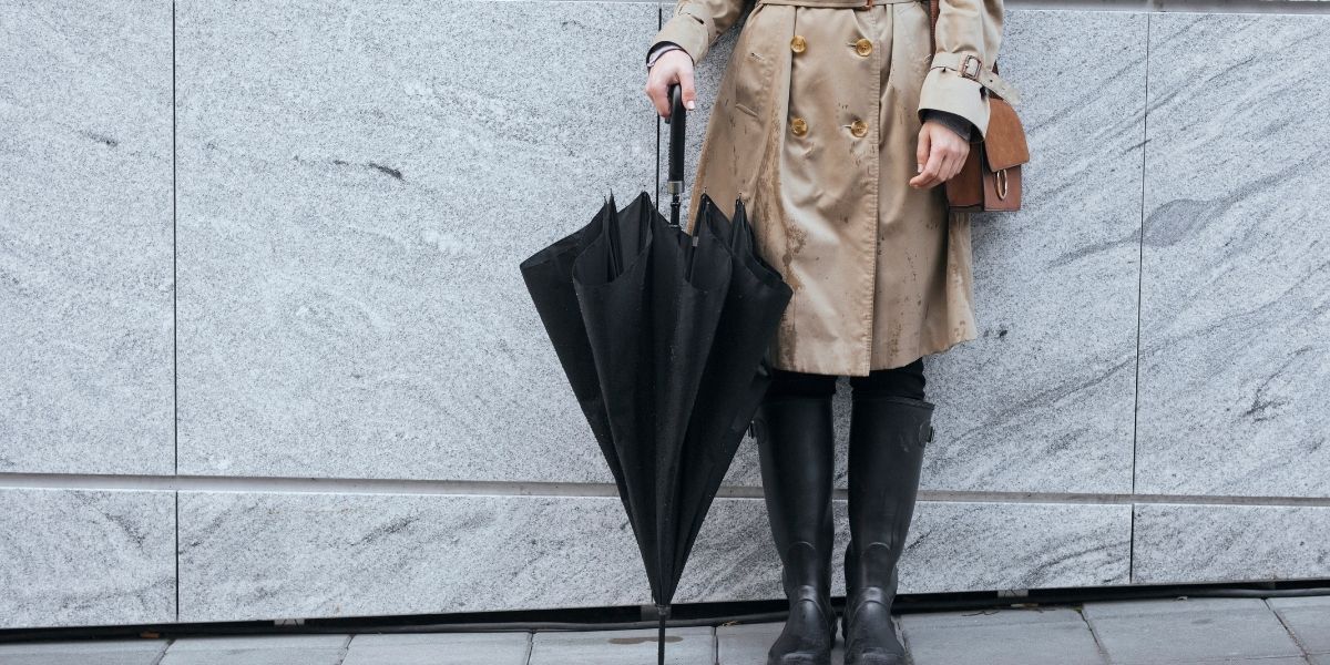 Personne portant une tenue anglaise et un parapluie